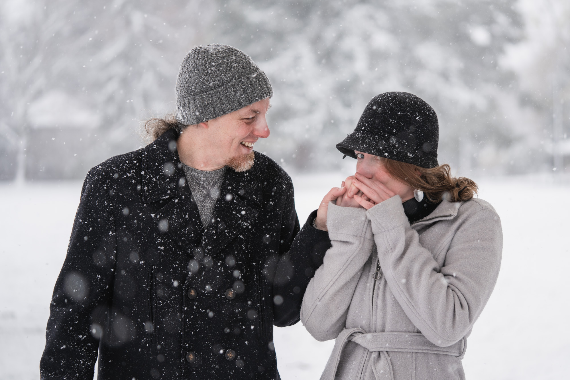 a couple warms their hands in the snow