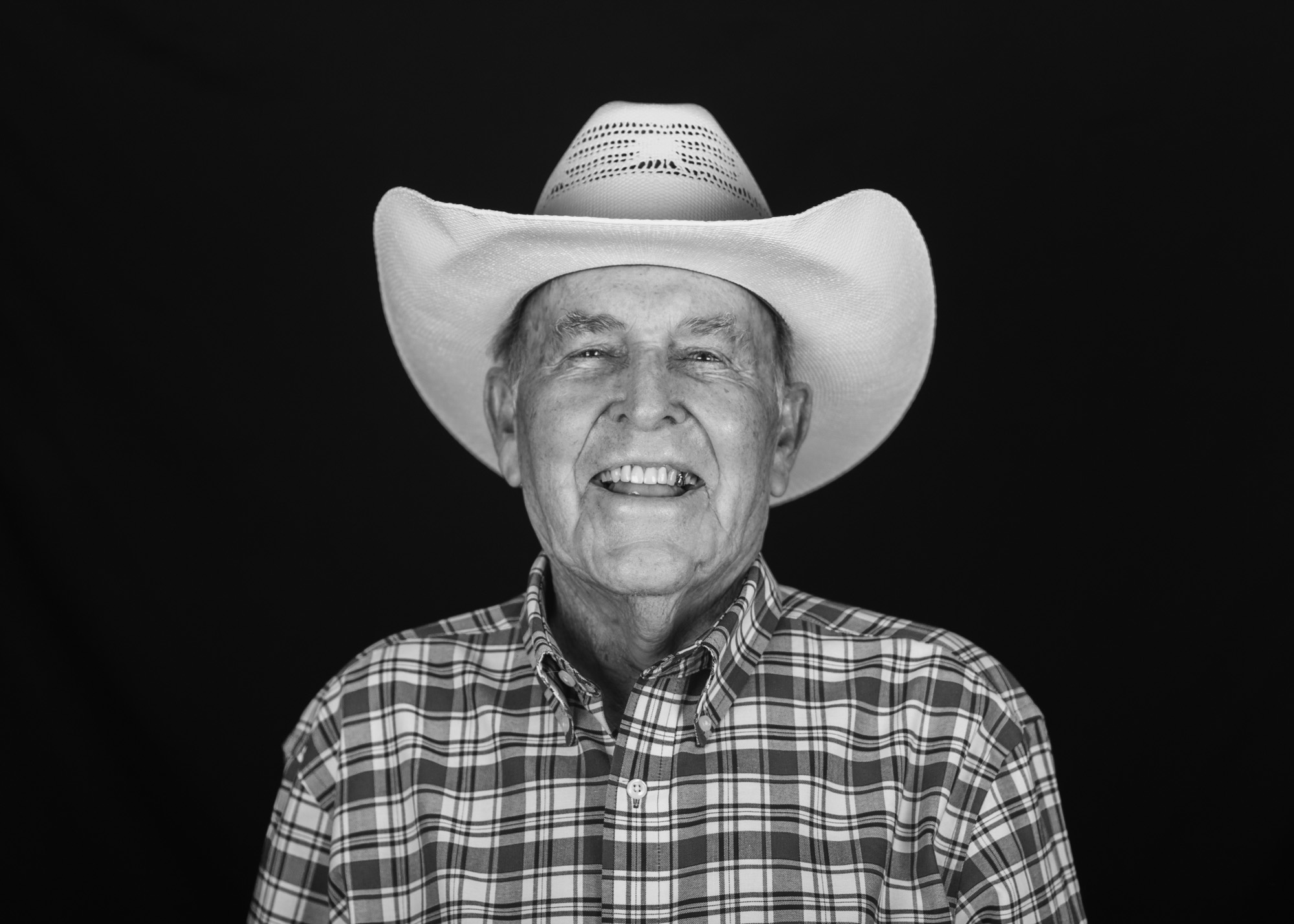 An laughing elder in a cowboy hat