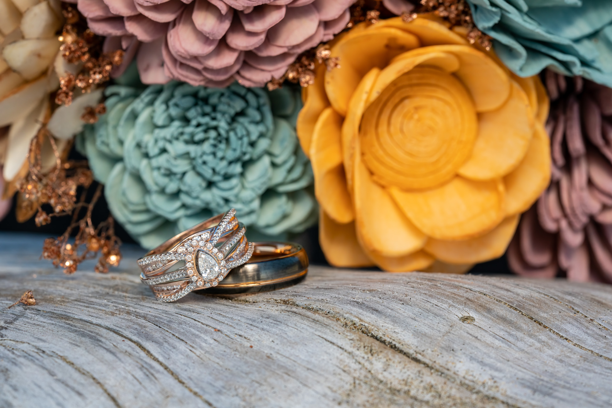 wedding rings next to wooden flowers