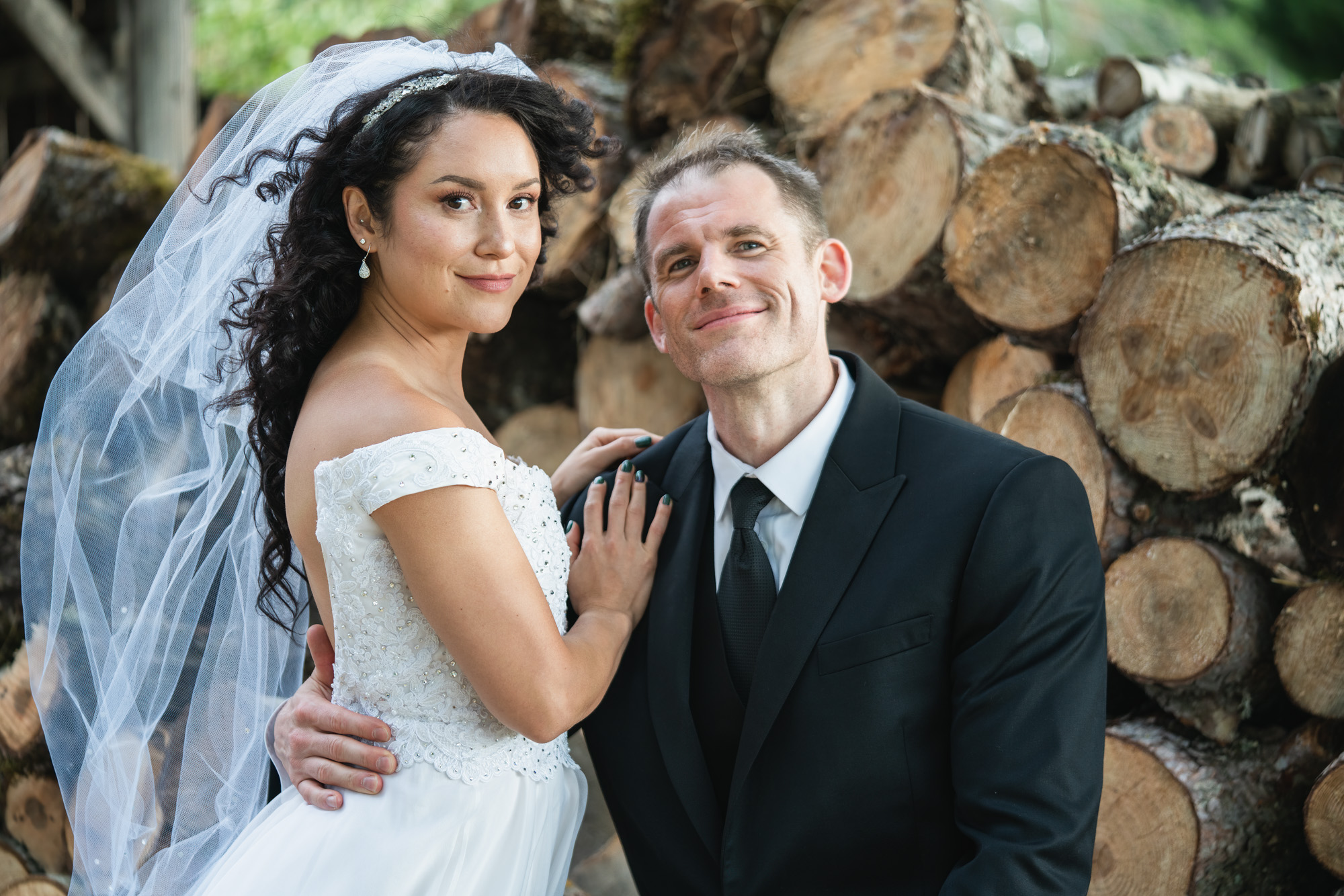 a bride with hair flowing in the air next to her groom